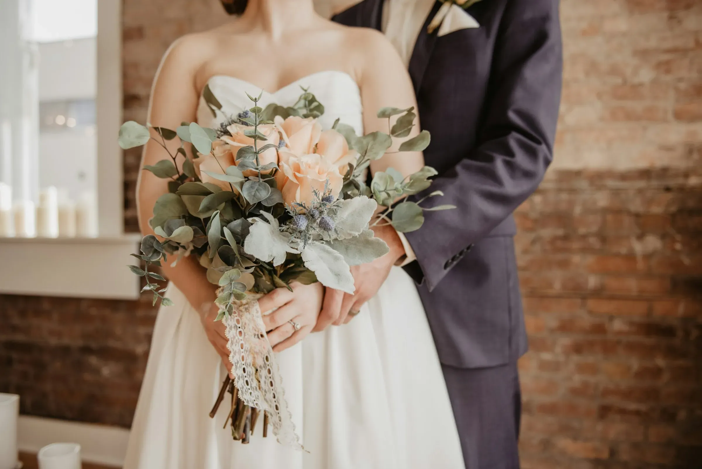 Close-up of a bride in a white dress with pearl details.